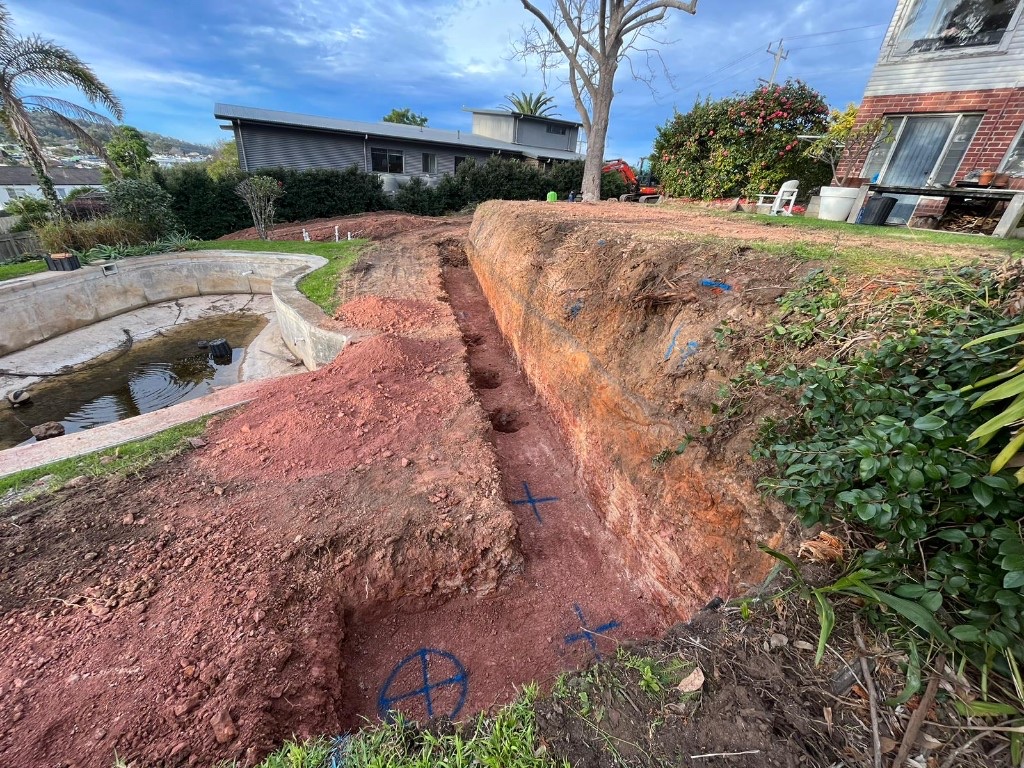 Backyard excavation trench beside an existing pool