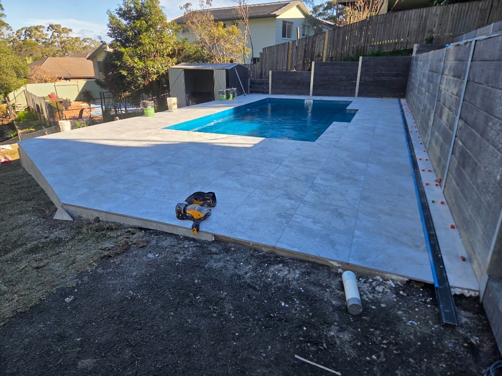 In-progress swimming pool with new patio tiling