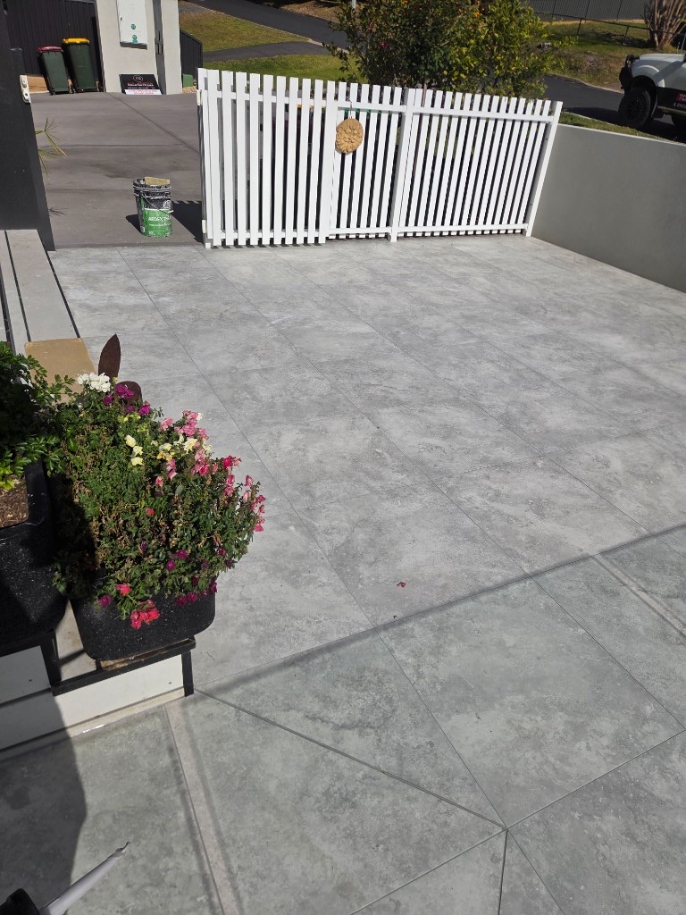 Completed outdoor patio tiling with planter